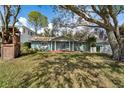 Charming blue brick home featuring a covered front porch with white columns, a wooden playhouse, and mature trees at 710 S Davis Blvd, Tampa, FL 33606