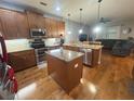 A spacious kitchen with wooden cabinets, stainless steel appliances, granite countertops, and an island is perfect for cooking at 1314 Riserva Ln, Palm Harbor, FL 34683