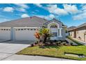 Charming one-story home with a well-manicured lawn, large garage, and appealing architectural details at 31806 Larkenheath Dr, Wesley Chapel, FL 33543