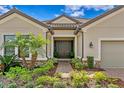 Inviting front entrance with stone accents, manicured shrubs and a brick walkway at 8733 Sorano Villa Dr, Tampa, FL 33647