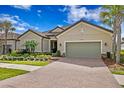 Beautiful home with brick driveway, manicured lawn, and a two-car garage, offering curb appeal at 8733 Sorano Villa Dr, Tampa, FL 33647