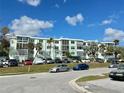 A full exterior of the condo building and parking lot with several cars on a beautiful day at 100 Waverly Way # 302, Clearwater, FL 33756