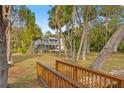 Beautiful two-story home with a wooden bridge, lush greenery, and partial view of the house at 906 W Henry Ave, Tampa, FL 33604