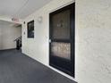 Condo front door with textured walls, neutral carpet, and small window offering natural light at 11485 Oakhurst Rd # A301, Largo, FL 33774