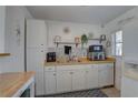 Bright kitchen with white cabinetry, butcher block countertops, and decorative backsplash tiles at 2311 Wellesley, Bradenton, FL 34207