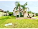 Lush front yard with mature palms and shrubs, enhancing the curb appeal of this well-maintained home at 4110 Huntingdale Ct, Wesley Chapel, FL 33543