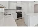 Modern kitchen features white cabinets, stainless steel appliances, and sleek countertops, offering style and functionality at 1255 Kazaz Ct, Zephyrhills, FL 33540