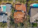 Stunning aerial view of a home with a red tile roof, lush landscaping, and a private pool at 1370 Brightwaters Ne Blvd, St Petersburg, FL 33704
