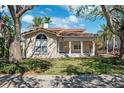 Charming home with a welcoming front porch, a large window, and a well-manicured lawn at 1370 Brightwaters Ne Blvd, St Petersburg, FL 33704