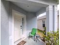 Covered front porch with a chair and table, offering a cozy outdoor seating area and welcoming entrance at 25925 Terrawood Loop, Land O Lakes, FL 34639