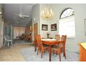 Traditional dining room featuring a chandelier, wood table, and view into the living room at 5565 Salem Square N Dr, Palm Harbor, FL 34685