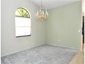 Empty room featuring a chandelier and an arched window at 5565 Salem Square N Dr, Palm Harbor, FL 34685