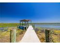 Waterfront dock with clear, blue sky and calm water, ideal for boating and fishing at 10532 94Th Pl, Seminole, FL 33772