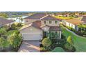 Beautiful two-story home boasts a tile roof, manicured landscaping, and a lake view at 6467 Willowshire Way, Bradenton, FL 34212