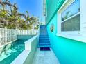 Picture shows the side of the home, stairs, pool, and backyard, with a beachy vibe at 308 2Nd St N # 202, Bradenton Beach, FL 34217