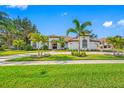 Beautiful single-story home featuring lush landscaping, a circular driveway, and a tile roof at 5501 E Longboat Blvd, Tampa, FL 33615