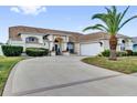 Beautiful single-story house with a wide driveway, attached two-car garage, and lush landscaping in a quiet neighborhood at 9229 Water Hazard Dr, Hudson, FL 34667