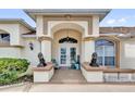 Inviting front entrance with double doors framed by columns and decorative lion statues on the porch at 9229 Water Hazard Dr, Hudson, FL 34667