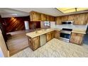 Charming kitchen with stainless steel appliances and wood cabinets open to adjacent living room at 1670 Monterey Dr, Clearwater, FL 33756