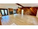 Spacious living room with wood paneling, fireplace and plenty of natural light from doors to patio at 1670 Monterey Dr, Clearwater, FL 33756