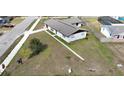 Aerial view of a cozy home with a spacious front yard and a clear blue sky at 5729 13Th St, Zephyrhills, FL 33542