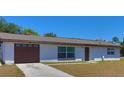 Single story home features a garage, green lawn, and a neutral color scheme at 5729 13Th St, Zephyrhills, FL 33542