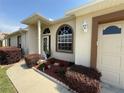 Charming home entrance with manicured garden beds, and neutral exterior colors at 9337 Zamora Dr, New Port Richey, FL 34655