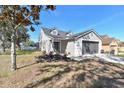 Beautiful two-story home featuring a gray garage door, well-manicured lawn, and lovely landscaping at 1764 Oak Spring Dr, Tarpon Springs, FL 34689