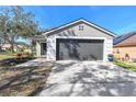 Charming home featuring an attached two-car garage and well-maintained front yard at 1764 Oak Spring Dr, Tarpon Springs, FL 34689