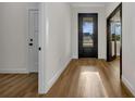 Light-filled hallway featuring hardwood floors, neutral walls, and modern doors at 2436 Jacobs St, Port Charlotte, FL 33953