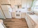 Cozy kitchen featuring white appliances, laminate counters, wood cabinets, and updated wood-look flooring at 6075 Shore S Blvd # 605, Gulfport, FL 33707