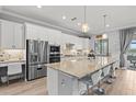 Bright kitchen features stainless steel appliances, a large center island with bar seating, and a built-in desk area at 5749 Cheech Gln, Bradenton, FL 34211