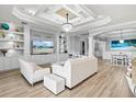 Open-concept living room with a custom entertainment center, stylish decor, and access to the dining area at 5749 Cheech Gln, Bradenton, FL 34211