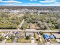 Wide aerial view of a single-Gathering home with mature trees, and expansive land in a rural community at 6706 Sierra Ter, New Port Richey, FL 34652