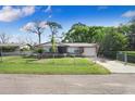 Charming brick home with fenced front yard, well-manicured lawn, and mature trees at 15808 Sea Pines Dr, Hudson, FL 34667