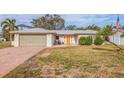 Charming single-story home featuring a vibrant orange front door and well-maintained landscaping at 10100 Paradise Blvd, Treasure Island, FL 33706