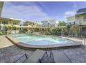 Community pool with deck and chairs, surrounded by well-maintained condo buildings and lush landscaping at 16333 Gulf Blvd # 105, St Petersburg, FL 33708
