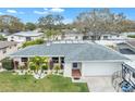 Charming single-story home with manicured lawn, vibrant landscaping, and a gray roof at 1672 Cambridge Dr, Clearwater, FL 33756