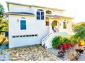 Two-story home with a two-car garage, beautiful landscaping, and private entry steps at 2902 N Shoreview Pl, Tampa, FL 33602