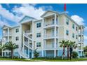 Stunning exterior of a multi-story condo featuring balconies, white railings, and lush landscaping at 7611 34Th W Ave # 303, Bradenton, FL 34209