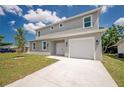 Two-story home featuring a gray exterior, a well-manicured lawn, and an attached single-car garage at 3801 Luma Dr, Holiday, FL 34691