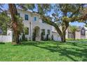 Charming two-story white home featuring a manicured lawn and tasteful landscaping at 4614 W Tennyson Ave, Tampa, FL 33629