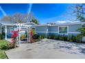 View of the light-blue home featuring well-maintained landscaping and a bright, sunny sky at 245 58Th N St, St Petersburg, FL 33710