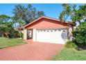 Close-up of a single-story home with brick driveway and attached garage in a peaceful neighborhood at 7425 118Th Dr, Largo, FL 33773