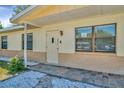 Inviting front entrance with a stone walkway, neutral exterior, and well-placed windows at 540 Florida S Cir, Apollo Beach, FL 33572