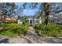 Beautifully landscaped home featuring lush greenery and a brick pathway leading to the entrance at 135 Aranda Ne St, St Petersburg, FL 33704