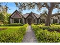 Charming front entry with gravel pathway, wooden door, stone facade and lush landscaping at 3005 S Miller Rd, Valrico, FL 33596
