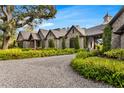 Beautiful stone home with a large driveway, manicured lawn, and gorgeous, mature landscaping at 3005 S Miller Rd, Valrico, FL 33596