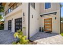 Beautiful modern home featuring a stylish wood front door, two-car garage, and landscaped entrance at 531 Danube Ave, Tampa, FL 33606