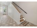 Hallway and staircase featuring a modern design with wood steps and sleek black railing at 531 Danube Ave, Tampa, FL 33606
